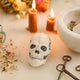 A handmade felted and embroidered Human Skull Ornament featuring embroidered bone, teeth, and crack details for a delightfully spooky addition to Halloween décor.