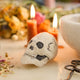 A handmade felted and embroidered Human Skull Ornament featuring embroidered bone, teeth, and crack details for a delightfully spooky addition to Halloween décor.