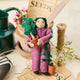 For the person who always has room for just one more plant, our Plant Parent Ornament celebrates the love, care, and wonderfully leafy obsession of keeping a home full of green things. Handcrafted from natural wool by skilled artisans, this whimsical felt ornament features a proud plant parent dressed in purple and happily surrounded by an abundance of potted greenery.