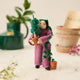 For the person who always has room for just one more plant, our Plant Parent Ornament celebrates the love, care, and wonderfully leafy obsession of keeping a home full of green things. Handcrafted from natural wool by skilled artisans, this whimsical felt ornament features a proud plant parent dressed in purple and happily surrounded by an abundance of potted greenery.