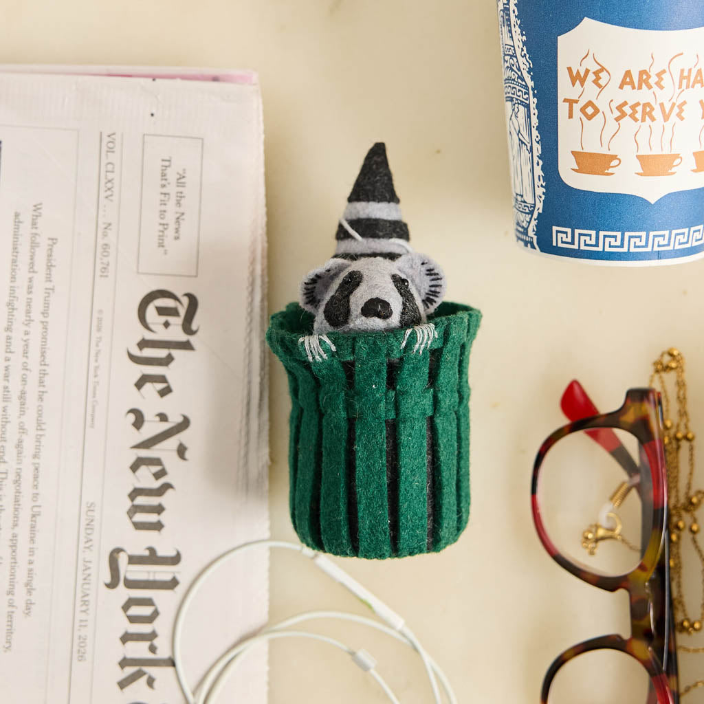 Every city has its unofficial mascot, and New York's just might be the mischievous raccoon. Meet our Trash Raccoon Ornament, peeking curiously from inside a classic green city trash can with the sweetest little face you've ever seen. Don't worry—this tiny trash panda is all charm and absolutely no trouble.