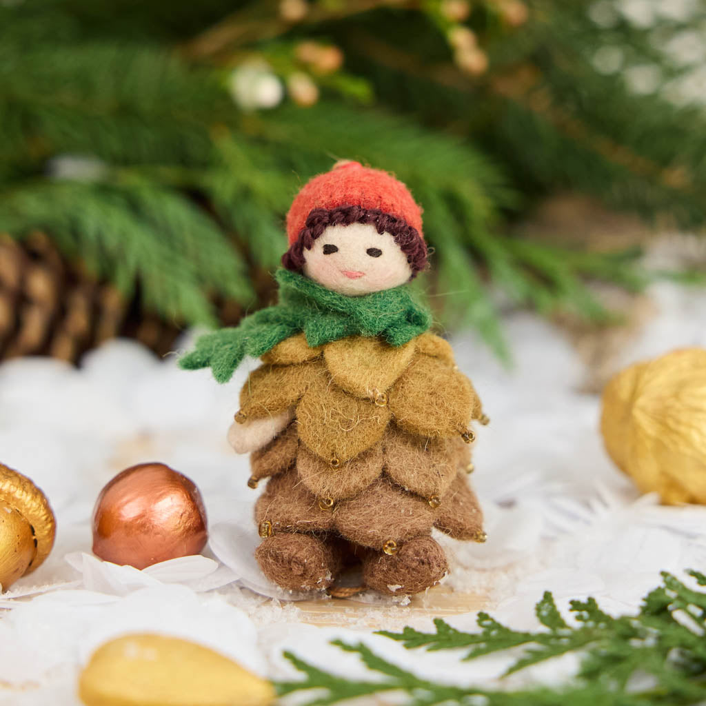 Waldorf-inspired, our Little Pinecone Kid Ornament captures the whimsical spirit of a woodland fairy tale. With its cute woolen bonnet, it's pine-green scarf and lovely layered pinecone petals and sweet as can be felted booties - this pinecone child is ready to capture woodland hearts.