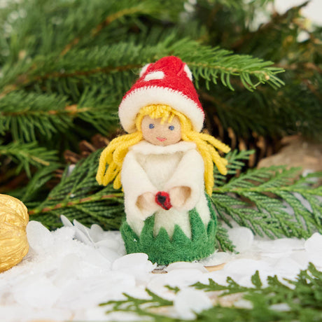 A magical little child of the forest, bringing good fortune, woodland wonder, and a sprinkle of fairy-tale enchantment into your home all year round! This sweet little red Amanita mushroom girl ornaments features a bright red felted mushroom cap, dotted with delicate white spots, and a skirt hemmed with felted green grasses. 