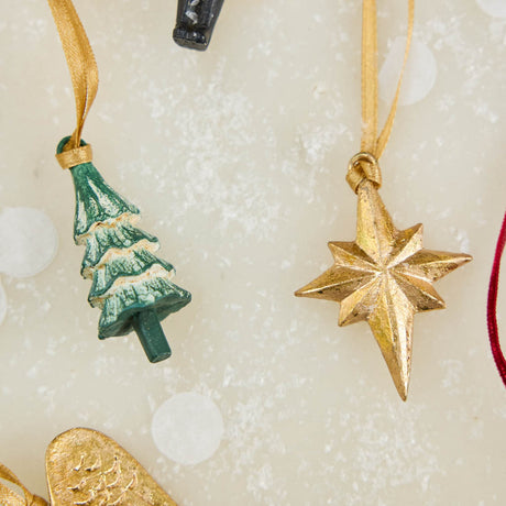 A set of eight hand-painted mini Christmas ornaments featuring nostalgic holiday icons, each finished with a golden satin ribbon and tucked into a reusable cotton gift pouch. Made to last and keep forever.