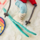Our Alpine Skier Ornament is ready to carve through the holiday season in style. Dressed in a bright red ski jacket, powder-blue pants, and matching goggles, this spirited skier comes complete with turquoise skis and poles, capturing the thrill of a perfect day on the mountain.