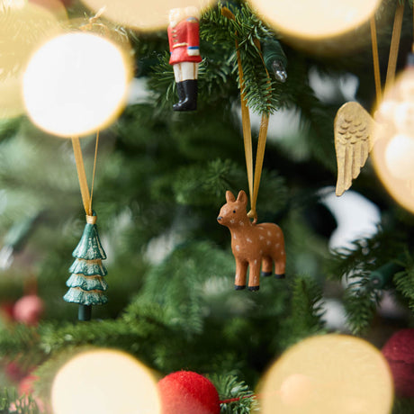 A set of eight hand-painted mini Christmas ornaments featuring nostalgic holiday icons, each finished with a golden satin ribbon and tucked into a reusable cotton gift pouch. Made to last and keep forever.