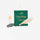 Miniature hand-felted wool ornament shaped like an open book titled A Christmas Carol, featuring embroidered details including a writing plume and a golden chamberstick. Crafted from merino-blend wool with a hanging string, the ornament evokes Victorian charm and the classic story of Ebenezer Scrooge. Measures approximately 2.25 inches high and 3.75 inches wide. GIF 360 degree view