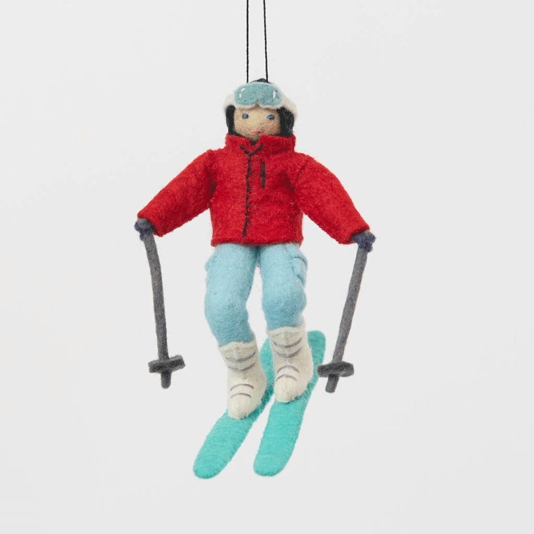 Our Alpine Skier Ornament is ready to carve through the holiday season in style. Dressed in a bright red ski jacket, powder-blue pants, and matching goggles, this spirited skier comes complete with turquoise skis and poles, capturing the thrill of a perfect day on the mountain.