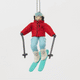 Our Alpine Skier Ornament is ready to carve through the holiday season in style. Dressed in a bright red ski jacket, powder-blue pants, and matching goggles, this spirited skier comes complete with turquoise skis and poles, capturing the thrill of a perfect day on the mountain.