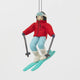 Our Alpine Skier Ornament is ready to carve through the holiday season in style. Dressed in a bright red ski jacket, powder-blue pants, and matching goggles, this spirited skier comes complete with turquoise skis and poles, capturing the thrill of a perfect day on the mountain.