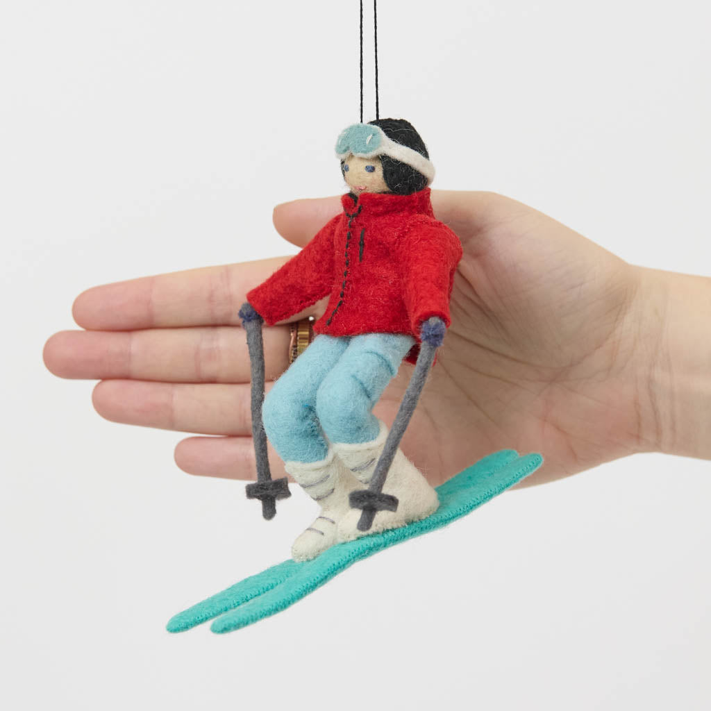 Our Alpine Skier Ornament is ready to carve through the holiday season in style. Dressed in a bright red ski jacket, powder-blue pants, and matching goggles, this spirited skier comes complete with turquoise skis and poles, capturing the thrill of a perfect day on the mountain.