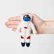 Hand-felted astronaut ornament with jetpack and space suit, celebrating space exploration and science. Handmade wool decoration, fair trade.