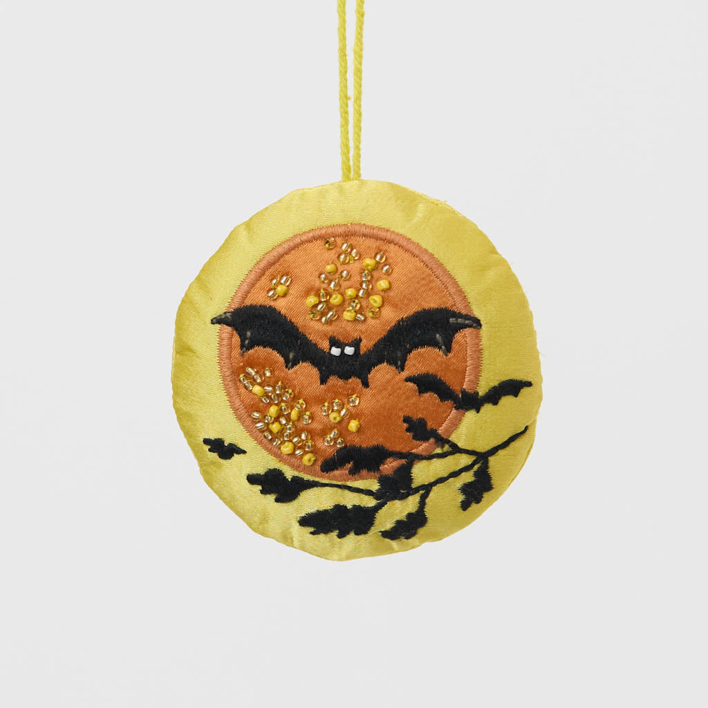 A double-sided handmade beaded Bat &amp; Moon Ornament featuring embroidered bats flying across a glowing full moon, with a playful “Swoop” design on the reverse.