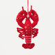 Commemorate the bounty of the northeastern seaboard with our handcrafted Bejeweled Red Lobster Ornament, designed to bring the spirit of coastal Maine to your home. Crafted from vibrant red felt and embellished with sparkling beads and sequins, this festive lobster ornament catches the light beautifully, adding texture, shimmer, and whimsical seaside charm to your holiday décor.