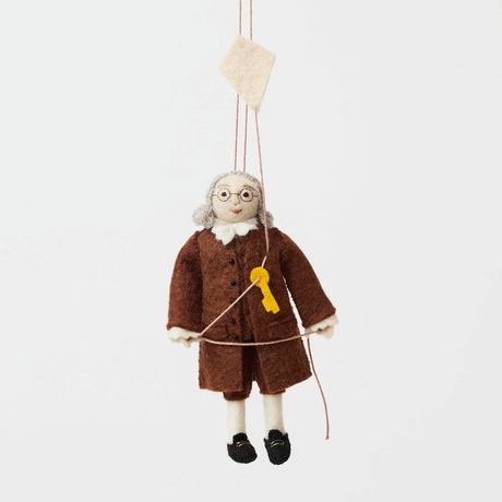 Honor the brilliance and ingenuity of a true American icon with our handcrafted Benjamin Franklin Ornament from the Craftspring Semiquincentennial Collection. Featuring Franklin in his classic colonial attire while flying a kite with a key