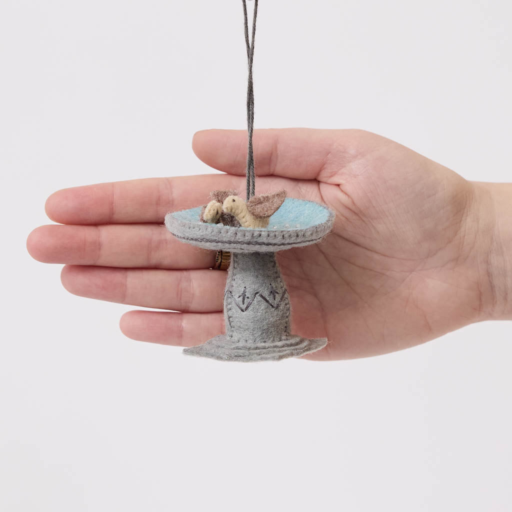 Celebrate the gentle rhythms of the garden with our Bird Bath Ornament. This charming felt scene features two tiny birds enjoying a quiet splash, capturing the simple joy of watching backyard birds gather for a drink on a sunny day.