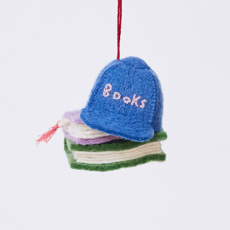 Handmade felt Books Are Magic Hat with Books ornament from Craftspring rotating to show front, side, and back views—whimsical blue hat on a stack of books, ethically crafted by artisans using sustainable wool.