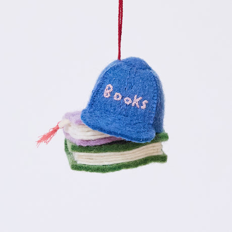 Handmade felt Books Are Magic Hat with Books ornament from Craftspring, featuring a whimsical blue hat resting on a stack of books—heirloom-quality Christmas decor, ethically crafted by artisans using sustainable wool.