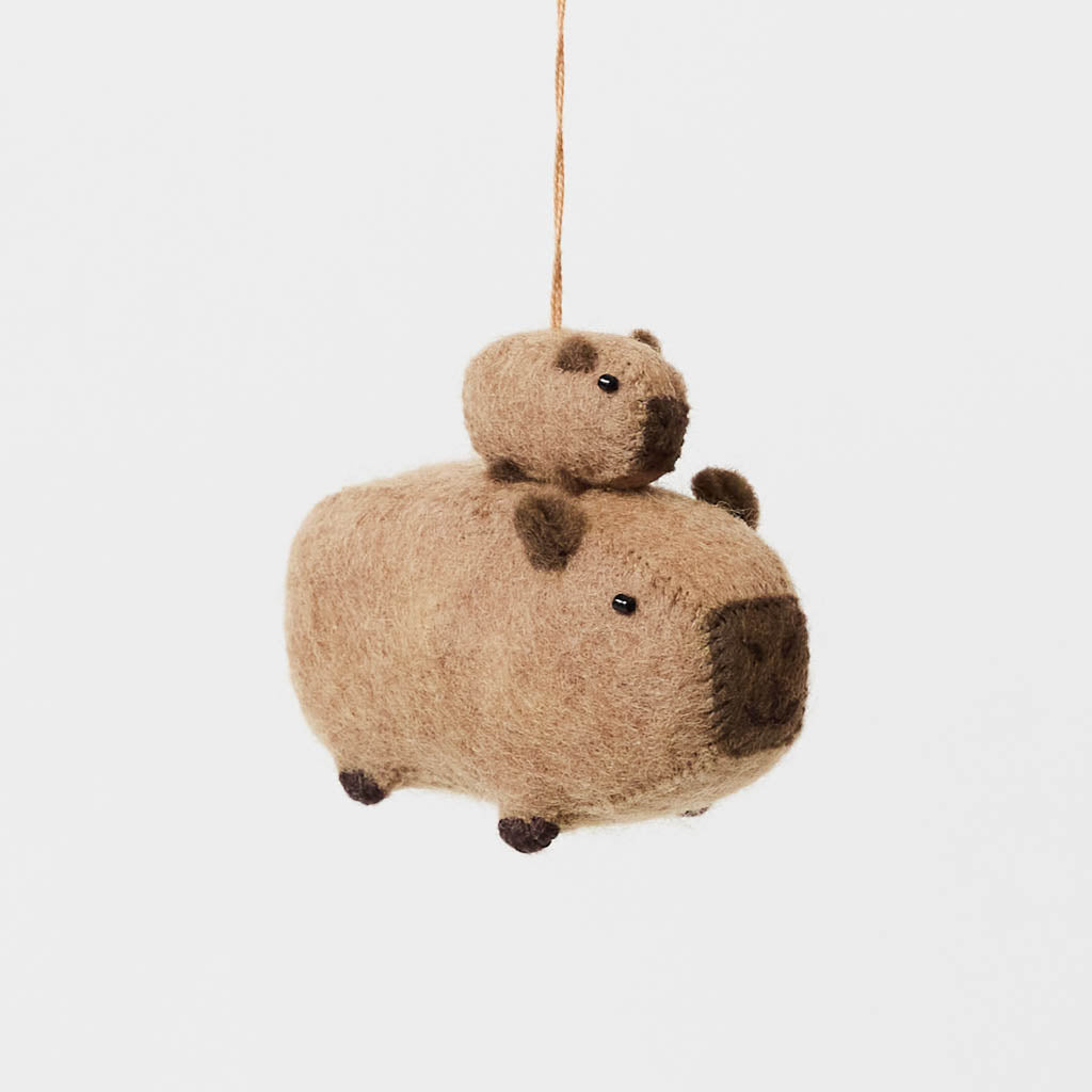 A handmade felt capybara and baby ornament from Kyrgyzstan. Cute as can be —perfect for meaningful gifting and cozy decor.