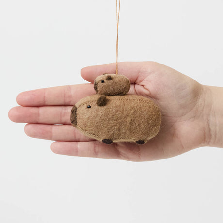 A handmade felt capybara and baby ornament from Kyrgyzstan. Cute as can be —perfect for meaningful gifting and cozy decor.