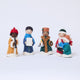 Handmade felt Carolers Set of 5 ornaments from Craftspring, featuring four singers and one clarinet player dressed in vintage clothes, with applique and embroidered snow at their feet — sweet-faced holiday decor that can stand on a mantle or hang on a Christmas tree, ethically crafted by artisans using sustainable wool.