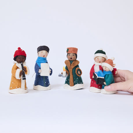 One caroler ornament from Craftspring’s Carolers Set of 5 held in hand to show its size — handmade felt holiday decor with sweet embroidered details and applique snow, ethically crafted by artisans using sustainable wool.