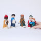 One caroler ornament from Craftspring’s Carolers Set of 5 held in hand to show its size — handmade felt holiday decor with sweet embroidered details and applique snow, ethically crafted by artisans using sustainable wool.