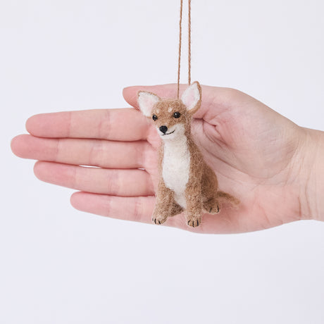 Craftspring’s Chihuahua Ornament displayed in front of a hand to show its size—needle-felted with big ears and a charming face, ethically crafted by artisans using sustainable wool.