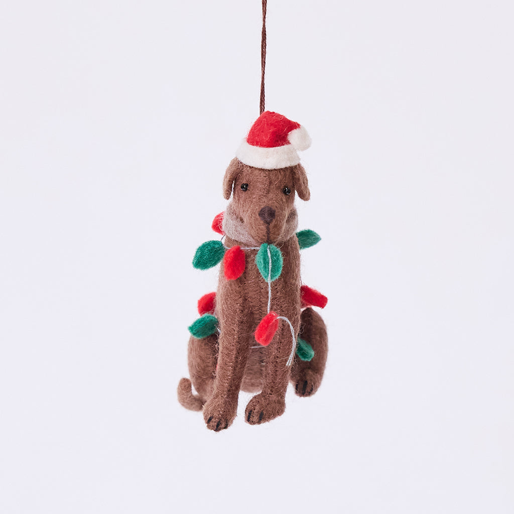 Craftspring’s Chocolate Lab in Christmas Lights Ornament — felt dog wrapped in Christmas lights and wearing a Santa hat, cute and festive — heirloom-quality Christmas ornament, perfect for holiday gifting, ethically crafted by artisans using sustainable wool.