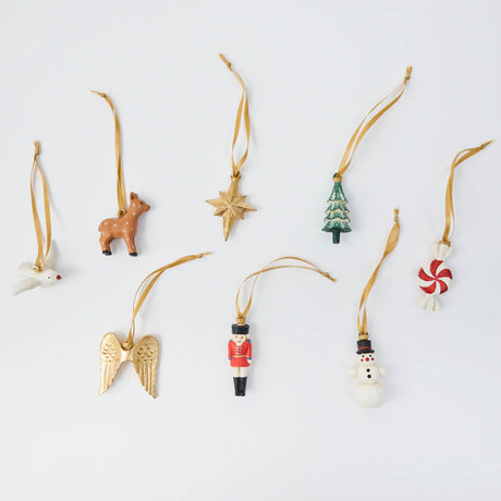 A Set of 8 mini xmas ornaments - from a little reindeer and snowman to a nutcracker, Christmas tree, dove, golden star, angel wings, and peppermint candy, every tiny ornament is hand-painted with charming details and finished with a golden satin ribbon. Together, they have the nostalgic feel of Christmas treasures collected over the years—only wonderfully mini.
