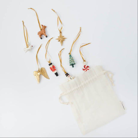 A Set of 8 mini xmas ornaments - from a little reindeer and snowman to a nutcracker, Christmas tree, dove, golden star, angel wings, and peppermint candy, every tiny ornament is hand-painted with charming details and finished with a golden satin ribbon. Together, they have the nostalgic feel of Christmas treasures collected over the years—only wonderfully mini.