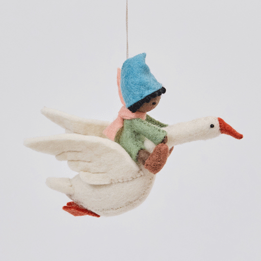 Handmade felt Cloud Dancer Dream Goose ornament – Brown – from Craftspring rotating to show front, side, and back views—featuring a detailed baby with brown skin and black hair riding a white goose, showcasing artisan craftsmanship and intricate stitching, ethically crafted using sustainable wool.