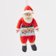 A hand-embroidered Santa Claus Christmas ornament with a red suit, white beard and hat, holding a baking tray with cookies, made from merino-wool.