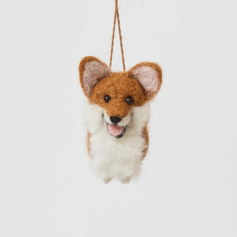 Bring a little wagging joy to your holiday decor with our irresistibly cute Felted Alpaca Corgi Ornament. Lovingly handmade by skilled artisans, this cheerful pup features the corgi’s signature golden coat, perky ears, and—of course—its famously adorable heart-shaped butt.