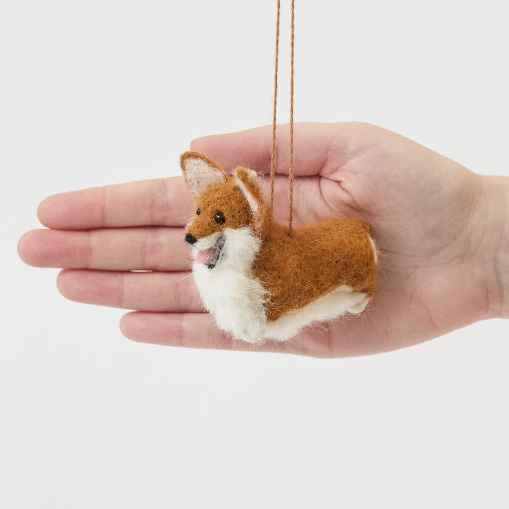Bring a little wagging joy to your holiday decor with our irresistibly cute Felted Alpaca Corgi Ornament. Lovingly handmade by skilled artisans, this cheerful pup features the corgi’s signature golden coat, perky ears, and—of course—its famously adorable heart-shaped butt.