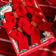A set of four red felt bows with beaded detailing, packaged in a box with a Christmas-themed design.