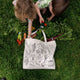 Two children unpacking a Farmers Market tote bag filled with real produce and felt ornaments of fruits and vegetables evoke summertime berry picking and garden freshness. A sweet gift for foodies, kids, or lovers of handmade seasonal décor.