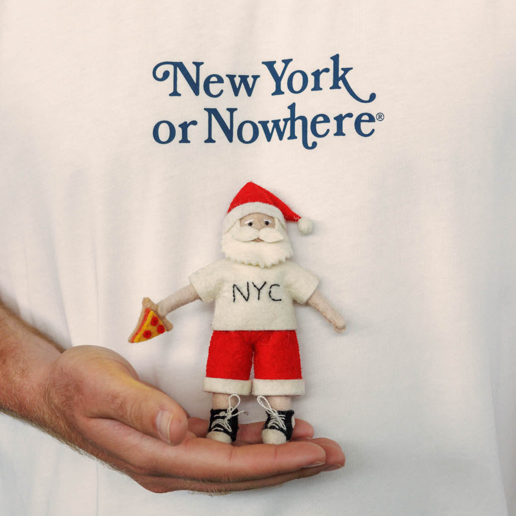 Celebrate Christmas in the Big Apple with our handmade NYC Santa Ornament, featuring Santa dressed like a true New Yorker with an NYC tee and a classic slice of New York pizza.

Who says Santa only runs on milk and cookies? After a busy night delivering gifts across the five boroughs, he's treating himself to a well-earned slice of New York pizza.