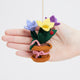 Handmade wool ornament with blooming crocuses, a felt bow, and whimsical insect accents