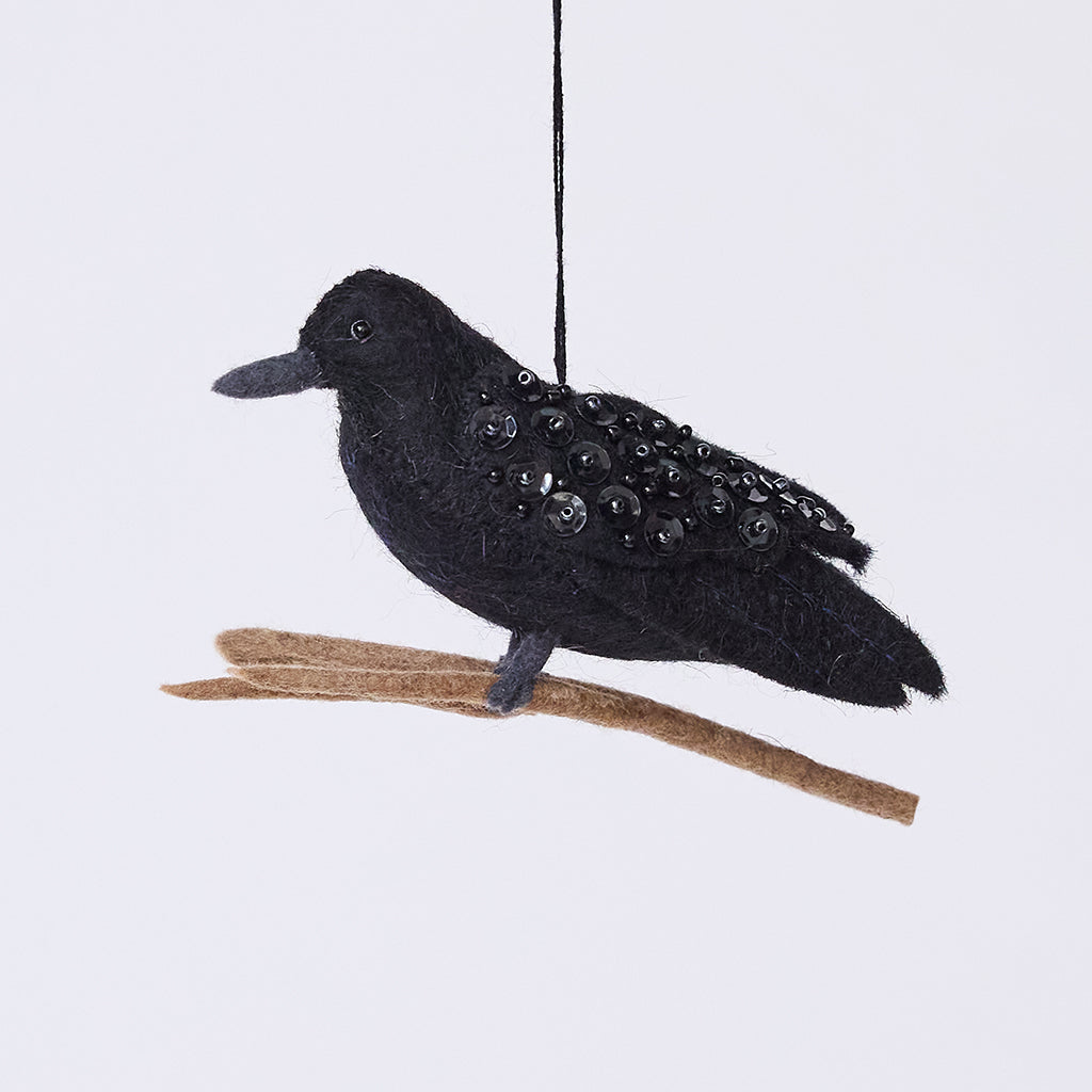 Handmade felt Crow ornament from Craftspring, featuring intricate beaded details and shimmering wings, perched on a branch—perfect for Halloween, autumn harvest, and holiday gifting, ethically crafted by artisans using sustainable wool.