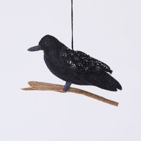 Handmade felt Crow ornament from Craftspring, featuring intricate beaded details and shimmering wings, perched on a branch—perfect for Halloween, autumn harvest, and holiday gifting, ethically crafted by artisans using sustainable wool.