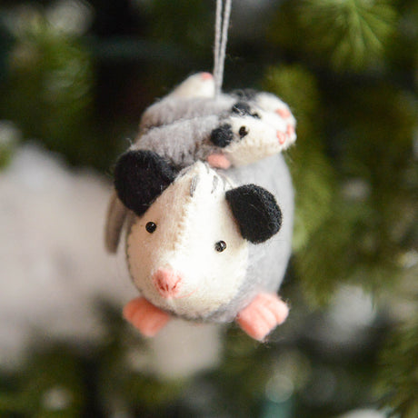 Handmade felt Opossum Mom with Babies Ornament from Craftspring hanging on a Christmas tree—mama opossum with cute babies on her back, embroidered and beaded details, heirloom-quality holiday decor ethically crafted by artisans using sustainable wool.