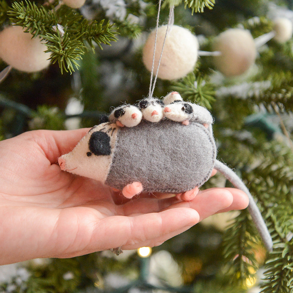Craftspring’s Opossum Mom with Babies Ornament shown in front of a hand to display size—sweet opossum family with intricate embroidery and beading, heirloom-quality Christmas decor ethically handmade by artisans using sustainable wool.