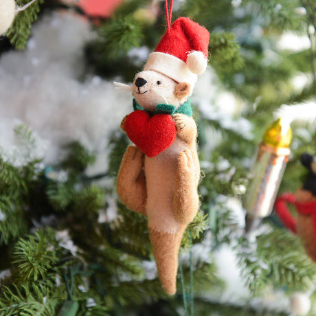Craftspring’s Santa Otter Love Ornament — a sweet otter wearing a Santa hat and holding a heart, detailed with soft embroidered holiday accents — displayed on a glowing Christmas tree, bringing warm, whimsical charm and gift-ready Christmas joy to festive decorating, ethically crafted by artisans using sustainable wool.