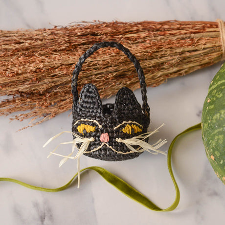 Adorably hand-crocheted, this black cat is ready for autumnal nights! Soft, lightweight, and ethically made, our mini raffia basket is perfectly sized for a little touch of joy. Fill it with treats and treasures for your fall table.&nbsp;