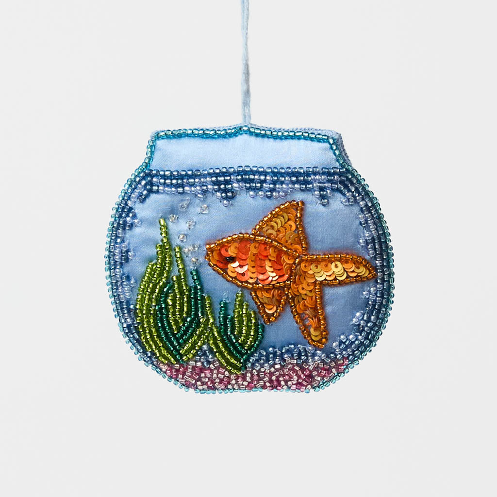 Make a splash with our whimsical Fishbowl Beaded Ornament! 🐠✨ This beautifully handcrafted ornament captures the charm of a beloved goldfish swimming peacefully through its miniature underwater world. Featuring a shimmering sequined goldfish, vibrant hand-beaded aquatic plants, and a sparkling fishbowl outlined with delicate glass beads, every detail is carefully stitched by hand to create a dazzling keepsake.