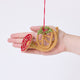 Craftspring’s French Horn Ornament displayed in front of a hand to show its size — handmade from sustainable wool with golden embroidery, beaded details, and mistletoe accents, ethically crafted by artisans.