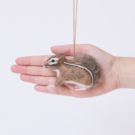 Craftspring’s Fuzzy Chipmunk ornament displayed in front of a hand to show its size — handmade from sustainable wool with stripes along its back and an adorable face, ethically crafted by artisans.