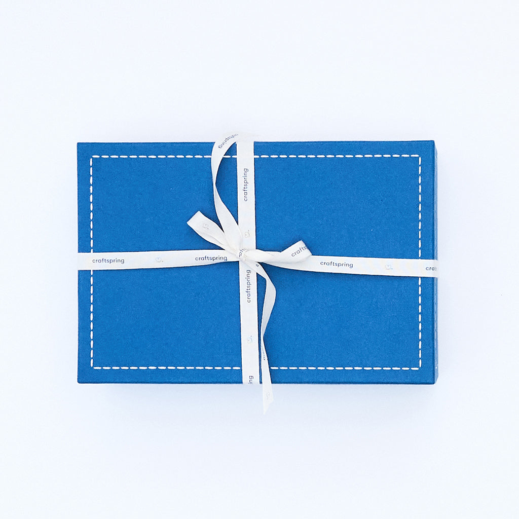 Craftspring blue gift box wrapped with a twill ribbon—high-quality holiday packaging, perfect for Christmas gifting, ethically crafted by artisans.