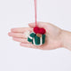 Craftspring’s Gift from the Heart Ornament displayed in front of a hand to show its size — felt heart ornament with beaded and embroidered details including a gift tag, perfect for Christmas and holiday gifting, ethically crafted by artisans using sustainable wool.